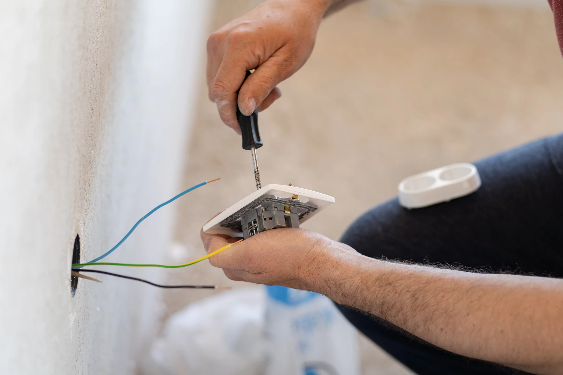 &Eacute;lectricien installant un interrupteur mural dans un int&eacute;rieur r&eacute;sidentiel