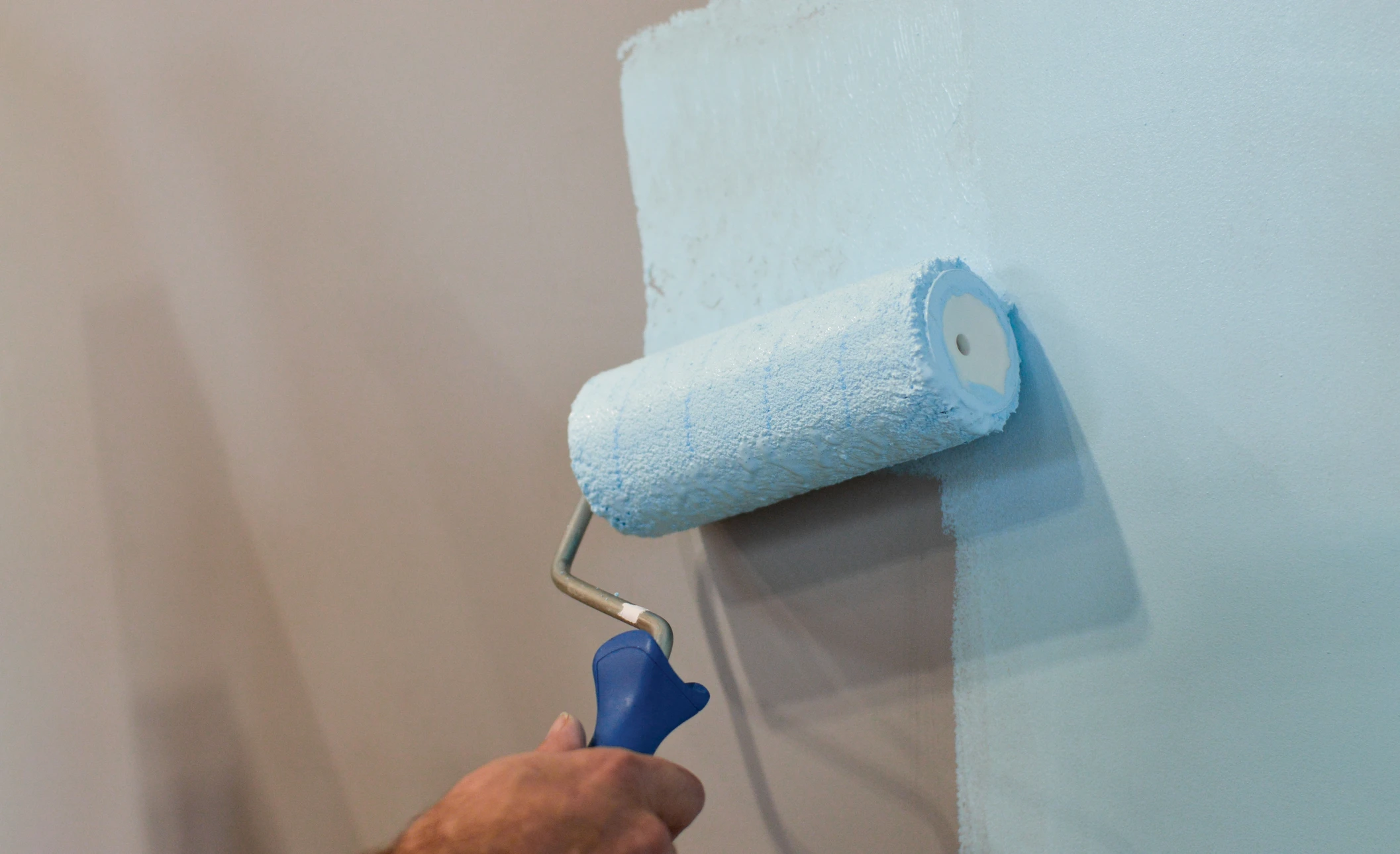 Photographie réelle d'un intérieur résidentiel moderne avec des murs fraîchement peints d'une couleur neutre et soignée, éclairage naturel mettant en valeur la qualité de la finition, sans personne visible, montrant clairement le travail de précision et le rendu professionnel d'une peinture intérieure de qualité.